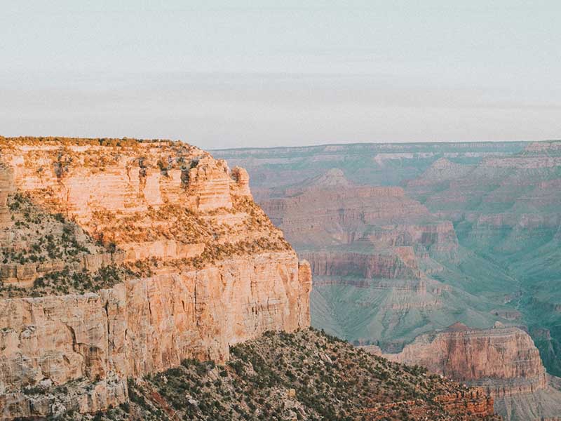 A close up view of a rock formation at the Grand Canyon, with ridges in the background